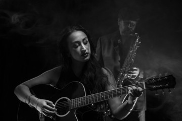 Obraz na płótnie Canvas Lady guitarist with a saxophonist