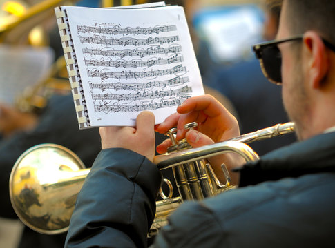 Detail of a musician plays the trumpet reading the score
