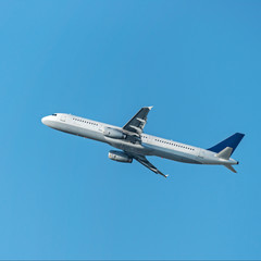 flying up passenger airplane isolated over blue sky background