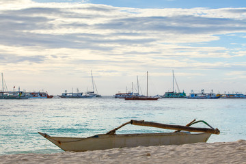 White boat on sand beach tropical sea on sunset