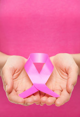 Woman holding a pink cancer awareness ribbon