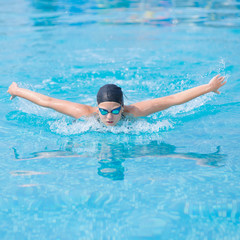 Young girl swimming butterfly stroke style