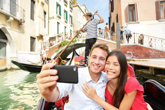 Selfie couple taking picture in Venice gondola
