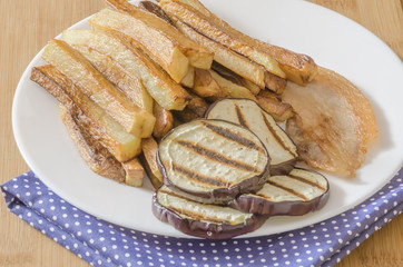 Fries potatoes with grilled eggplant on wooden background