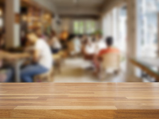 Empty wooden table and blurred people in cafe background