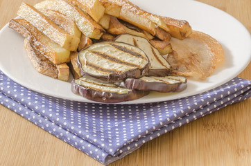 Fries potatoes with grilled eggplant on wooden background