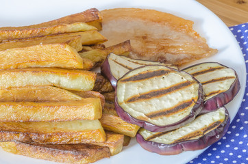 Fries potatoes with grilled eggplant on wooden background