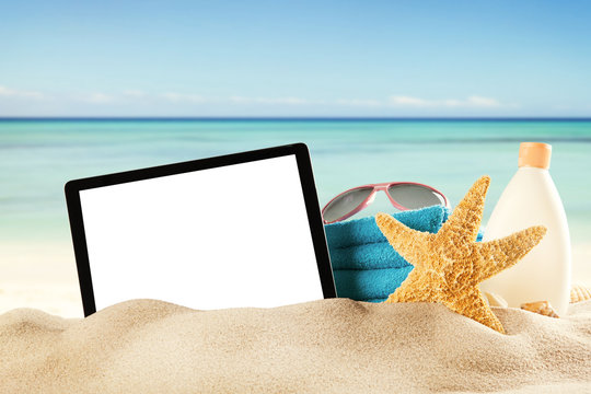 Summer beach with tablet in sand