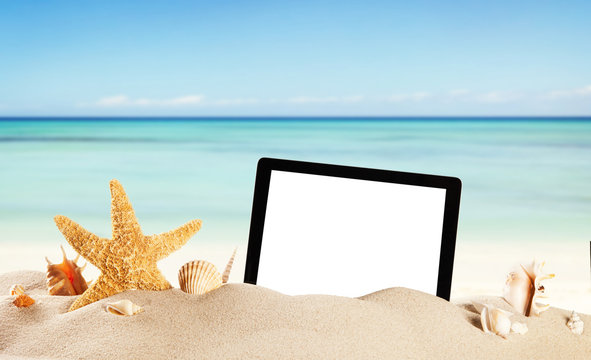 Summer beach with tablet in sand