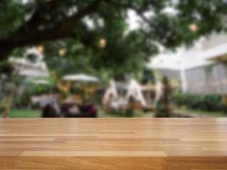 Empty wooden table and blurred outdoor cafe background