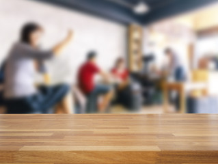 Empty wooden table and blurred people in cafe background