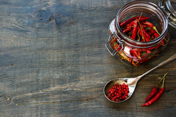 Chili Peppers in glass jar, herbs and spices