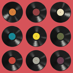 Vinyl records with colorful labels on red background.