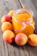 Jar of jam and ripe apricot fruits on table 