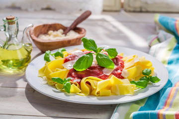 Homemade pappardelle pasta with tomato, basil and parmesan