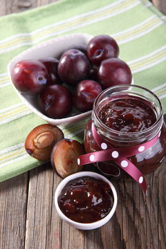 plums and jar of jam on table 