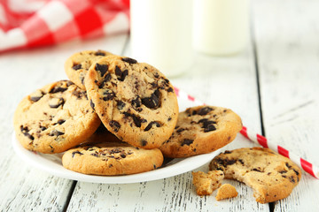 Cookies and glass of milk on white wooden background