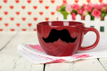 Red cup with paper mustache on colorful background