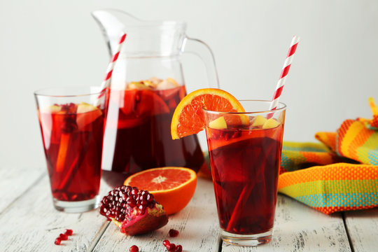 Jug ang glass of sangria on white wooden background