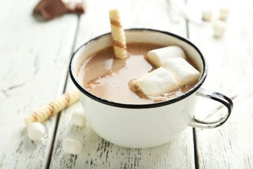Cup of hot chocolate with marshmallows on white wooden backgroun