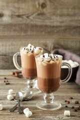 Glasses of hot chocolate with marshmallows on grey wooden backgr