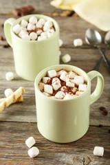 Cup of hot chocolate with marshmallows on grey wooden background