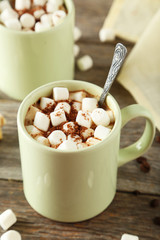 Cup of hot chocolate with marshmallows on grey wooden background
