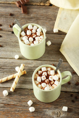 Cup of hot chocolate with marshmallows on grey wooden background
