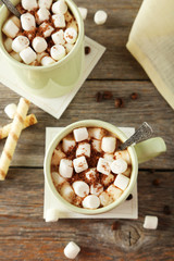 Cup of hot chocolate with marshmallows on grey wooden background