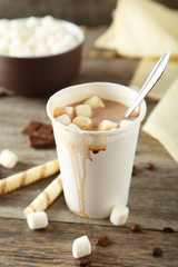 Cup of hot chocolate with marshmallows on grey wooden background