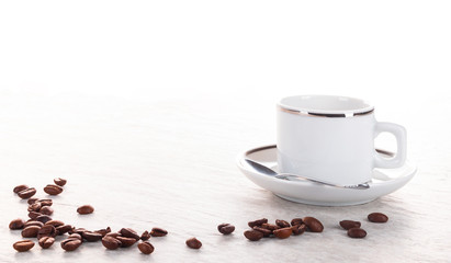 Kaffeebohnen und Kaffeetasse auf Steinplatte