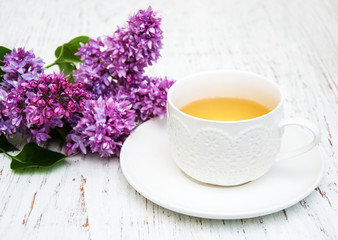 Cup of tea and lilac flowers