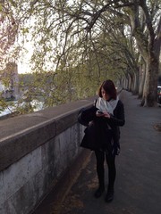 Fototapeta premium ragazza manda messaggio sul lungo tevere a roma