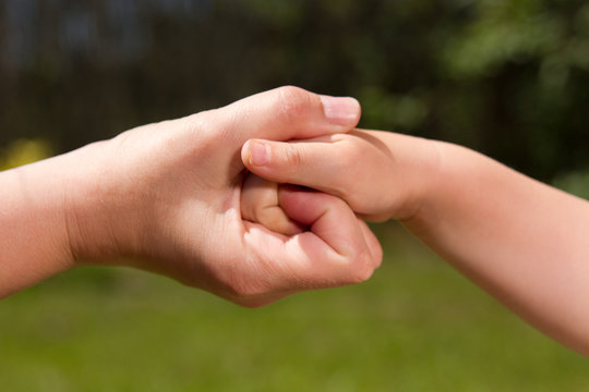 Zwei verschlungene Hände, Erwachsene und Kind Hand