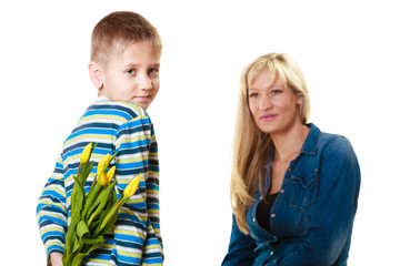 Child boy giving flowers his mother