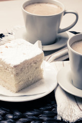 cup with coffee and cake on table