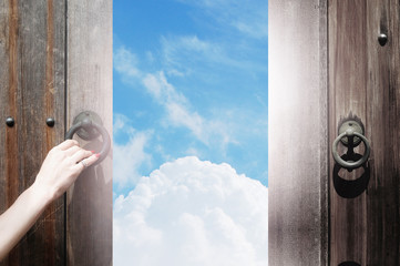古木戸を開ける手と青空と雲