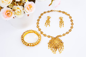 Golden Pair of earrings , Golden necklace and Golden bracelet on