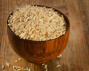 Raw brown rice in a wooden bowl.