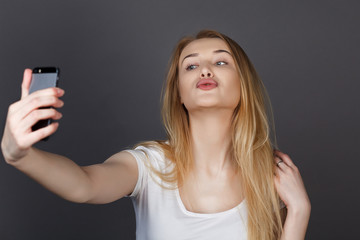 young pretty blonde women taking selfie on cell phone