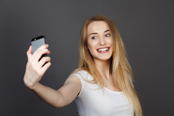 Fototapeta premium young pretty blonde women taking selfie on cell phone