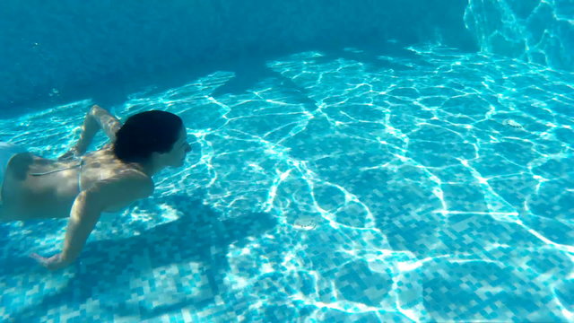 Woman swims and dives in the beautiful swimming pool, Video clip