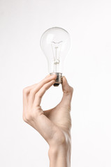 human hand holding a light bulb on a white background in studio