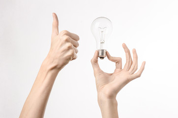 human hand holding a light bulb on a white background in studio
