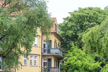Fototapeta na wymiar Altes Wohnhaus zwischen alten Bäumen im Augsburger Stadtteil Thelottviertel