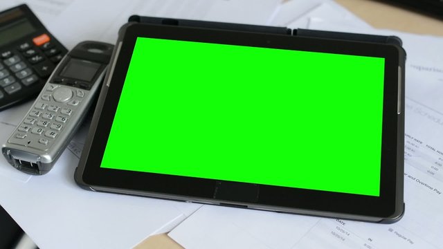 tablet - green screen - on the table in the office - phone with calculator