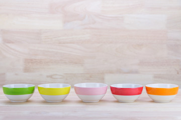 Colorful Ceramic Bowls Stacked On Each Other on Wood Background 