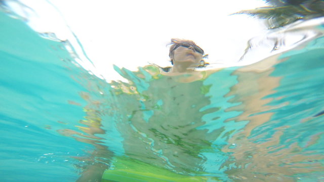 Woman walking in water with go pro camera