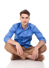 Fototapeta premium Handsome young man sitting with his legs crossed
