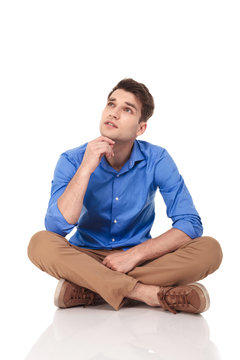 Young fashion man sitting with his legs crossed